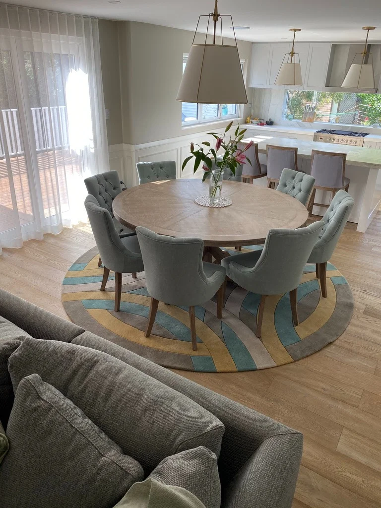 Open-plan dining and kitchen — circular timber dining setting, bespoke lighting and refined living space